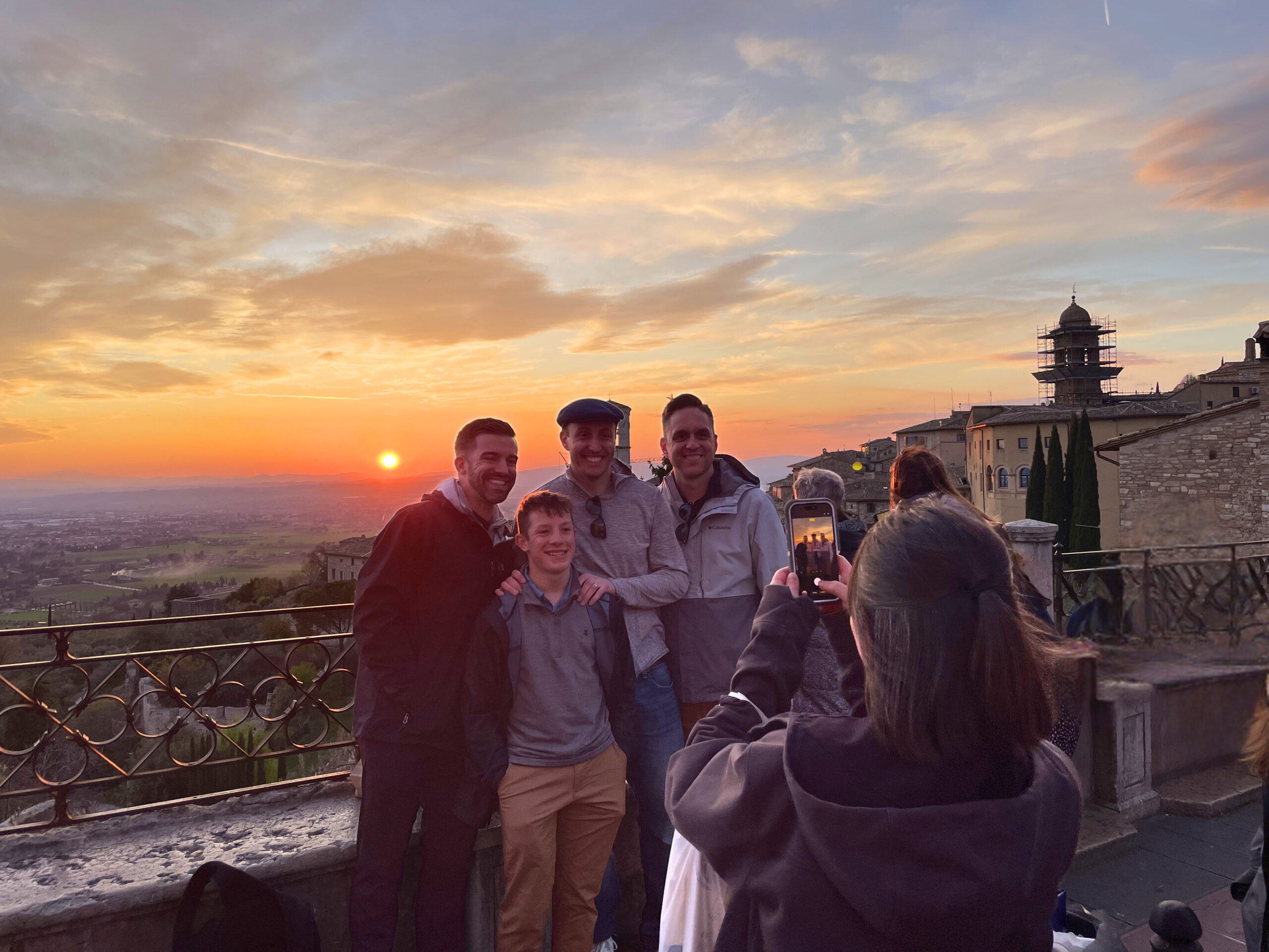 pilgrims enjoy a beautiful sunset in Assisi and pose for pictures